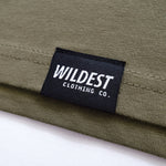 Close up of Wildest Clothing Co. brand tag on the bottom hem