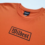 Close up of orange t shirt with black Wildest blackletter box print