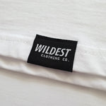 Close up of Wildest Clothing Co. brand tag on the bottom hem