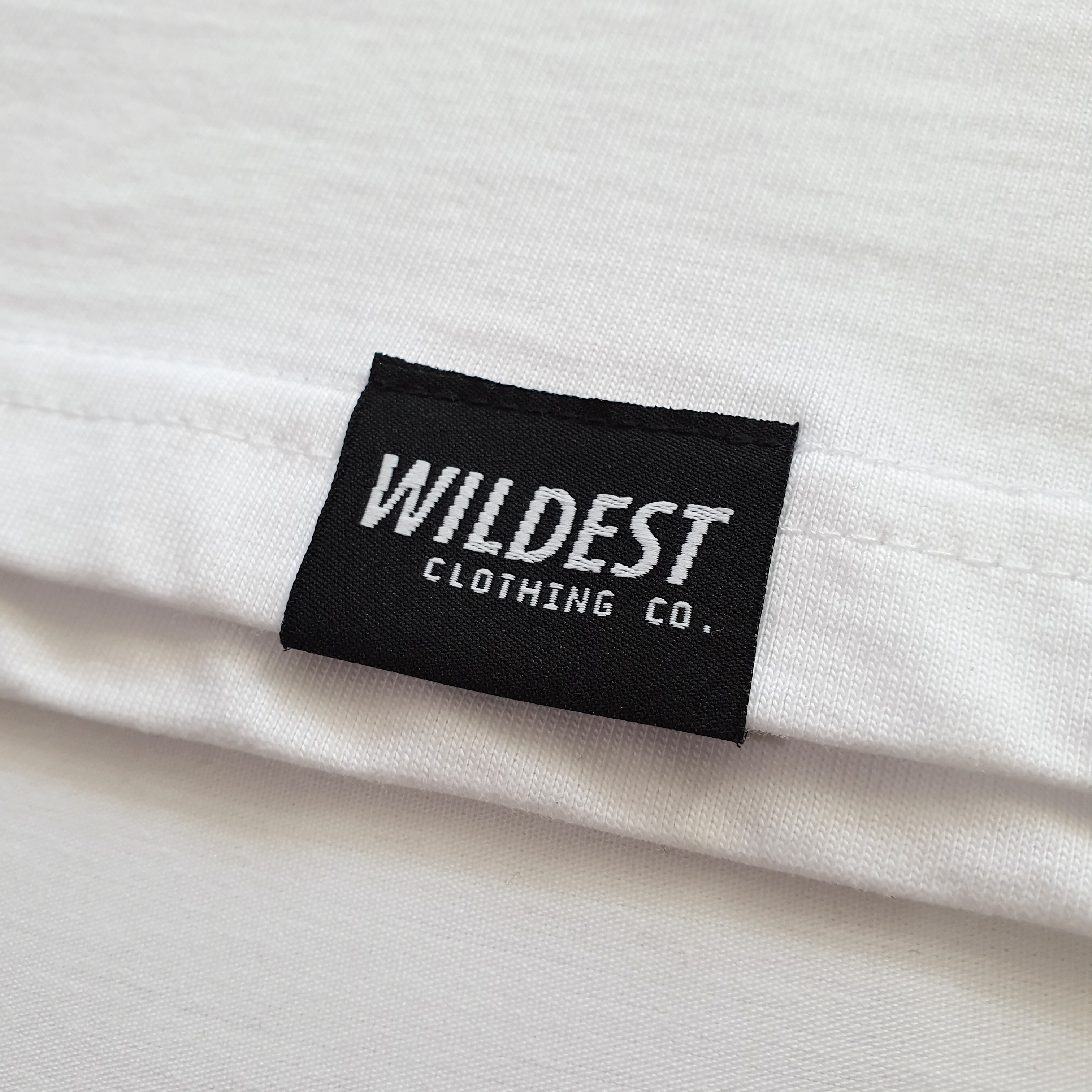 Close up of Wildest Clothing Co. brand tag on the bottom hem